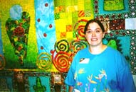 Andrea Stern poses in front of her quilt.