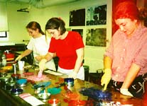 Amanda, Becky, and Sarah mix printing inks in the right shades for a proof.