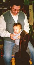 Jimmy holds Omari on the stitching horse.